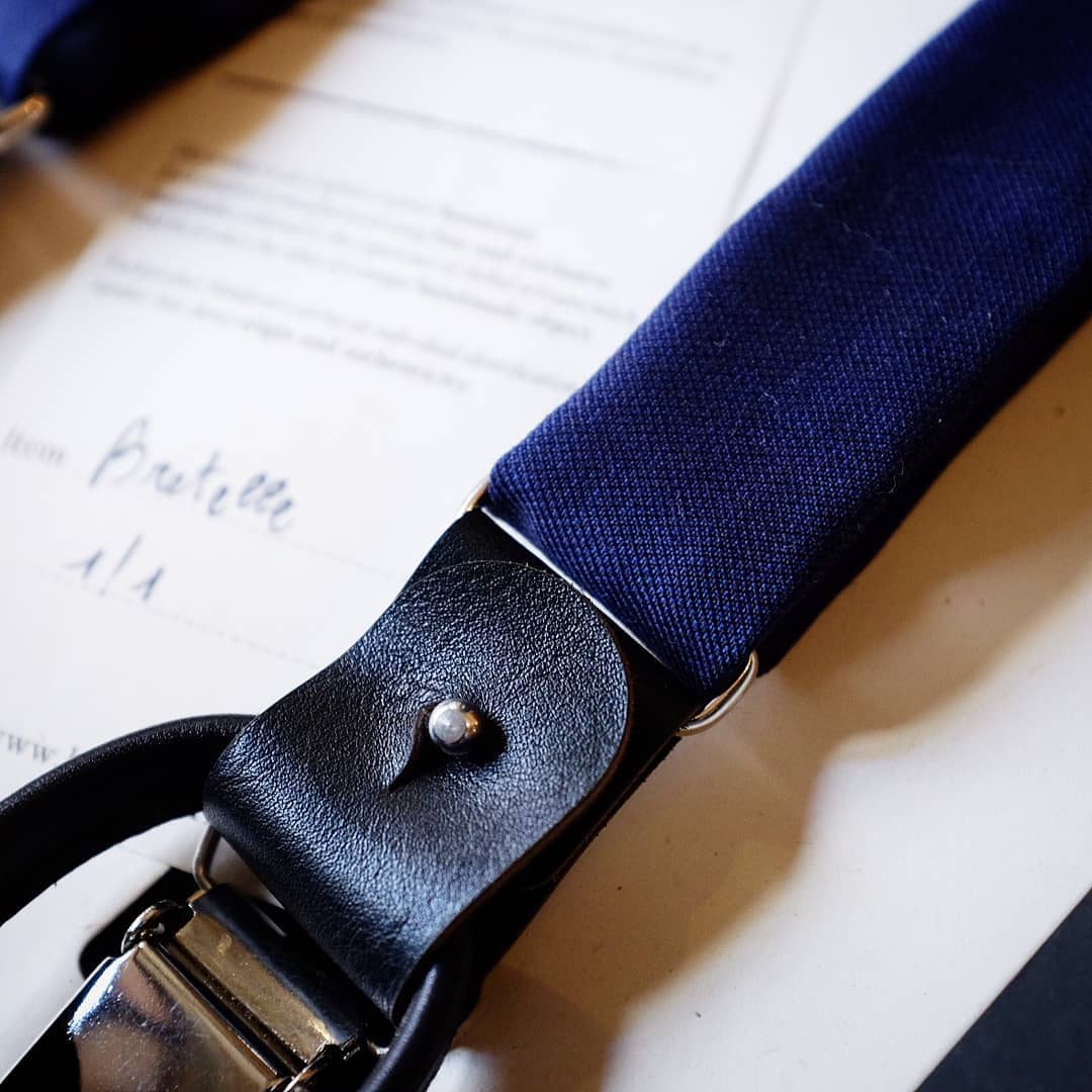 Dettaglio della fascia blu, della pelle e della clip delle bretelle Banderari