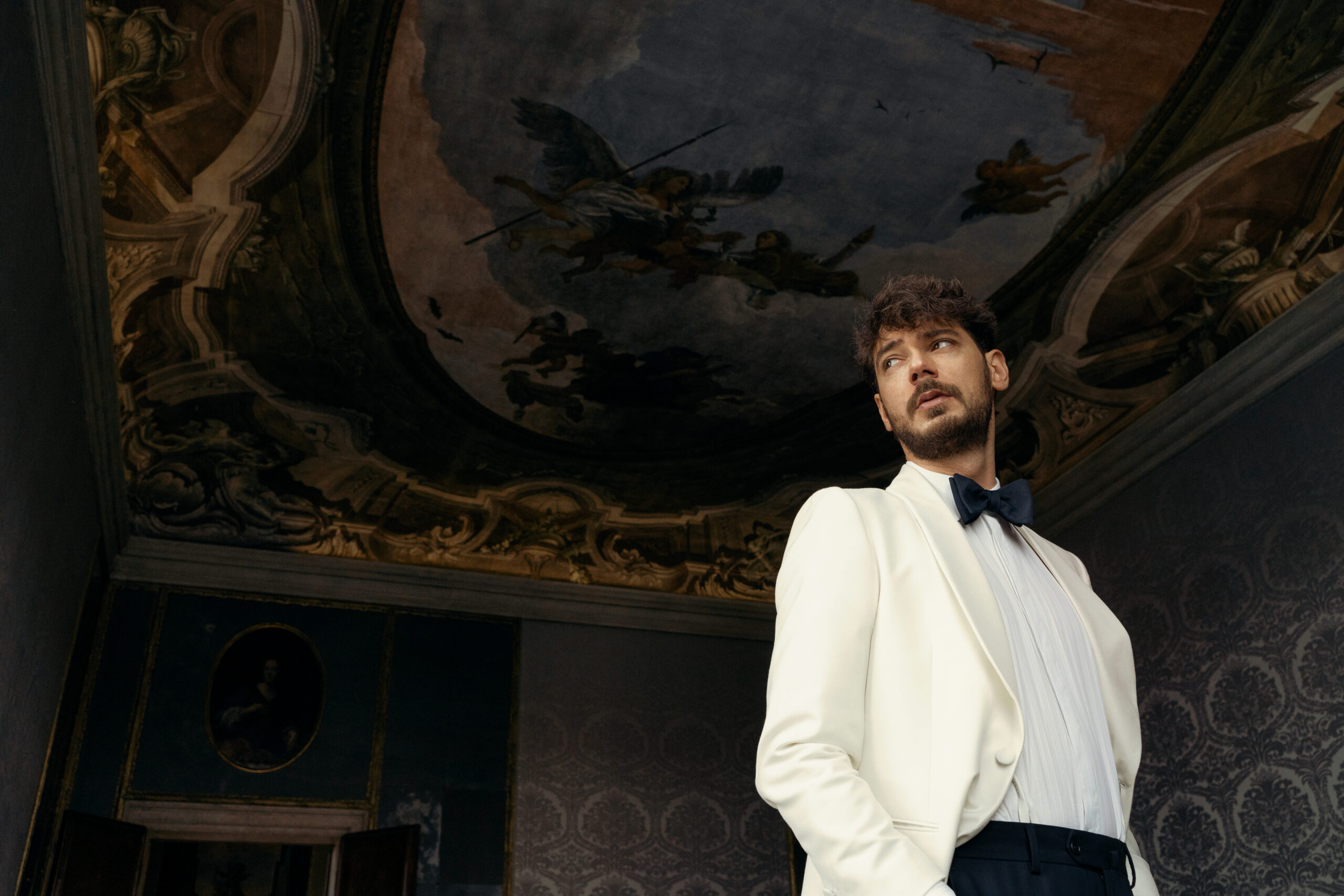 Andrea in smoking bianco e papillon Banderari negli interni dell’Aman Venice, campagna Luxus