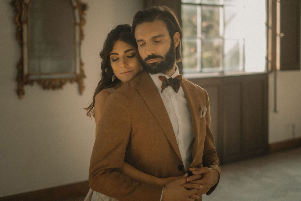 Due sposi che si abbracciano durante un matrimonio presso la Villa di Striano. L'uomo indossa un papillon Banderari.