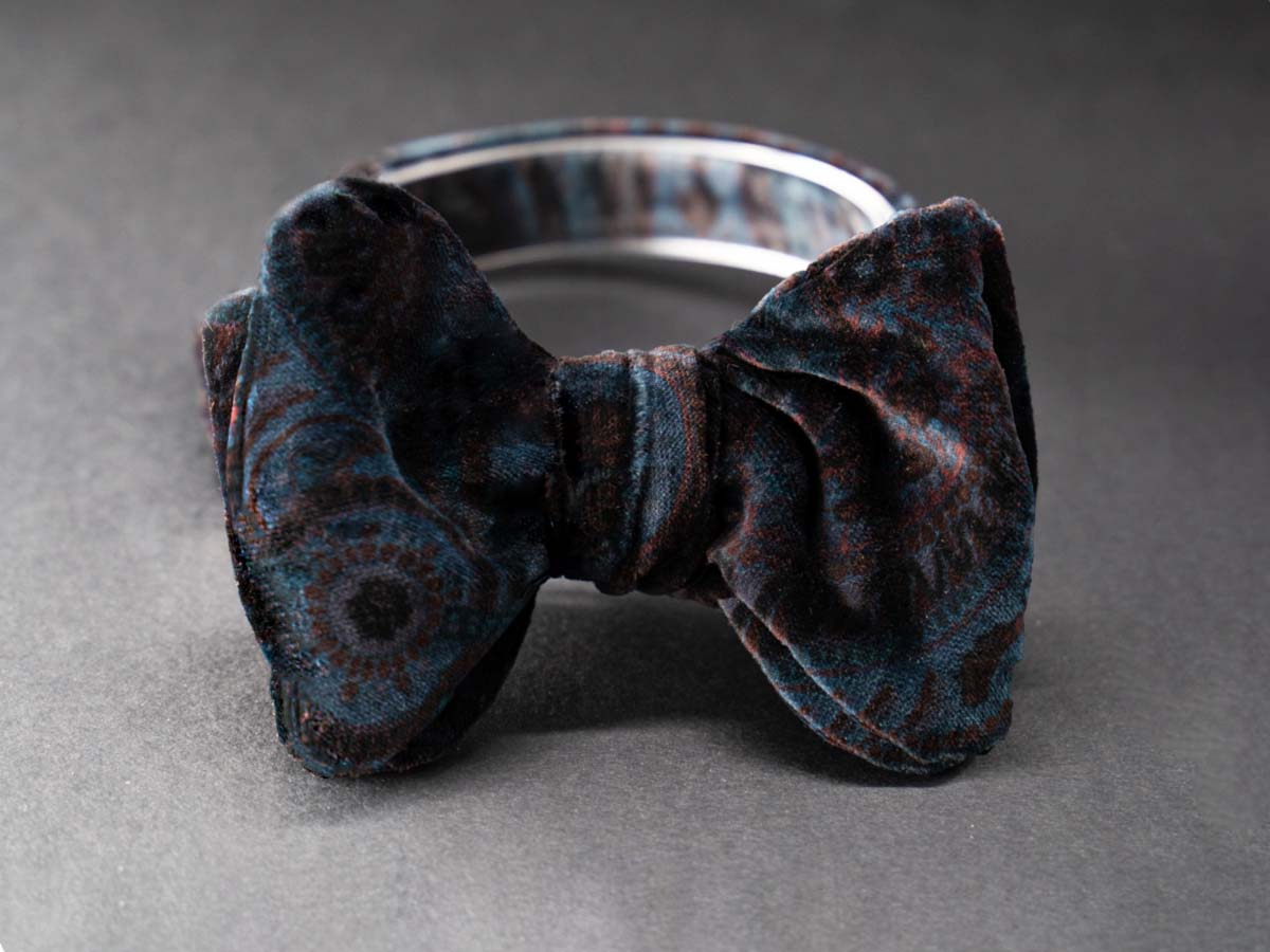 Elegant self-tie bow tie in blue and brick red paisley velvet.