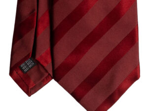Cravatta regimental nei toni del rosso sette pieghe realizzata a mano in Italia. Cravatta sartoriale a righe nei toni del rosso sette pieghe.