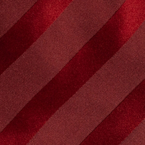 Cravatta regimental nei toni del rosso sette pieghe realizzata a mano in Italia. Cravatta sartoriale a righe nei toni del rosso sette pieghe.