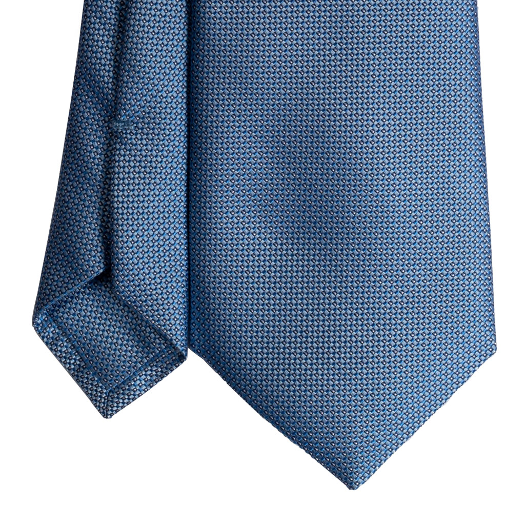 cravatta finto unito azzurro sette pieghe punta spillo realizzata a mano in Italia. Cravatta sartoriale punta spillo azzurro/grigio sette pieghe.