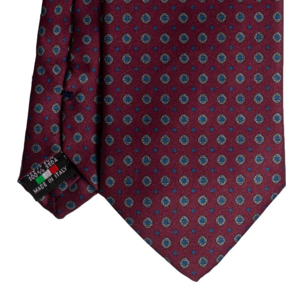 Cravatta rosso micro fantasia azzurro e beige in twill di seta tre pieghe realizzata a mano in Italia. Cravatta rosso bordeaux micro fantasia 3 pieghe