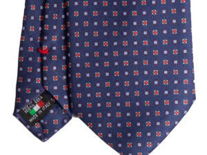 Cravatta blu micro fantasia rosso bianco e azzurro in twill di seta tre pieghe realizzata a mano in Italia. Cravatta sartoriale blu micro fantasia 3 pieghe