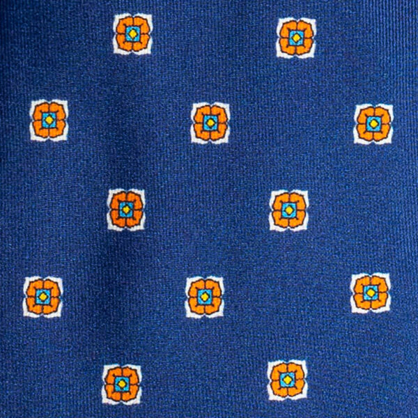 Cravatta blu micro fantasia arancione giallo e bianco sette pieghe in twill di seta realizzata a mano in Italia. Cravatta blu micro fantasia sette pieghe