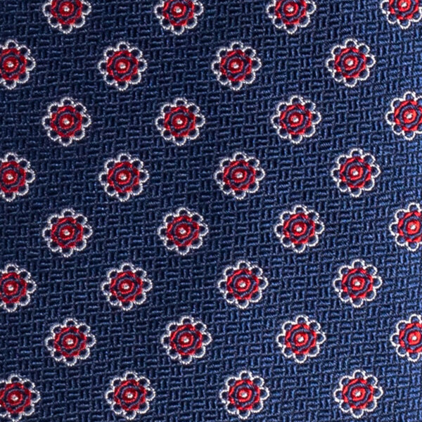 Cravatta blu micro fantasia floreale rosso bianco in seta jacquard sette pieghe realizzata a mano in Italia. Cravatta blu micro fantasia rosso sette pieghe