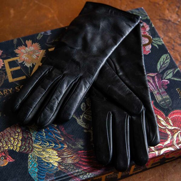 Eleganti guanti da donna in pelle nappa di agnello nero e dorso con tre cuciture foderati con una maglia in puro cashmere Made in Italy