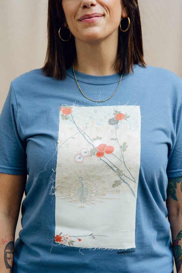 Ukiyo è una maglia t-shirt girocollo in cotone organico azzurra impreziosita da un pannello con fiori e pavone ricavata da un kimono degli anni ’60